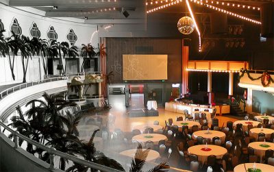 Historic Cocoanut Grove event space with tables, chairs and a stage