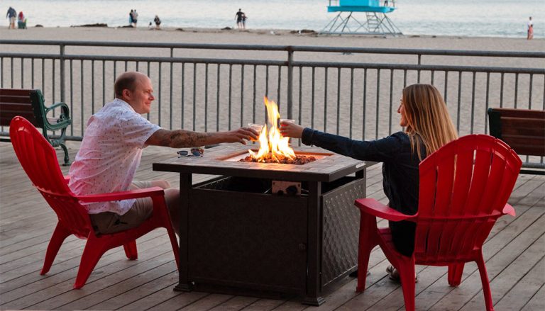 Couple toasting beers over firepit