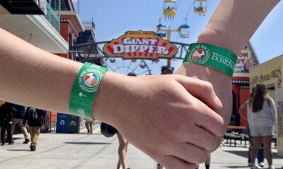 Two hands clasped with Boardwalk Ride Wristbands