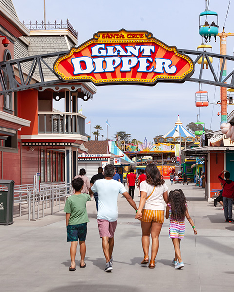 Family walking under the Giant Dipper sign